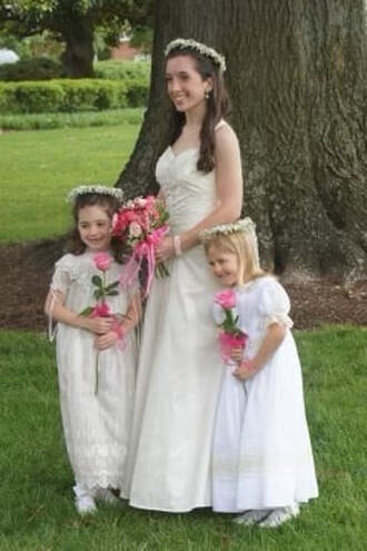 Hannah Kerlan ('23) smiles for a picture as a flower girl with her senior Meriwether Adams back in 2011 at St. Mary's graduation.