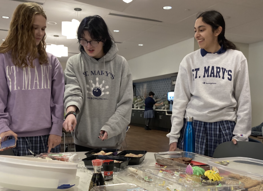 Students gather in the dining hall along with Environmental Club President Naisha Guar (right) for a bake sale fundraiser. Gaur organized this event to raise money to have compostable plates at lunch for two weeks. 