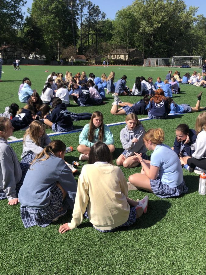 St. Marys Upper School spends time outside during their chapel time. There are options to walk the track, lay on the field or play in a game. 