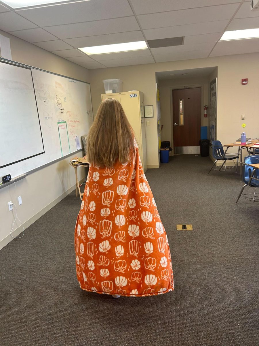 Freshman Jane Russell celebrates the cool weather wearing her pumpkin blanket to keep her warm. 