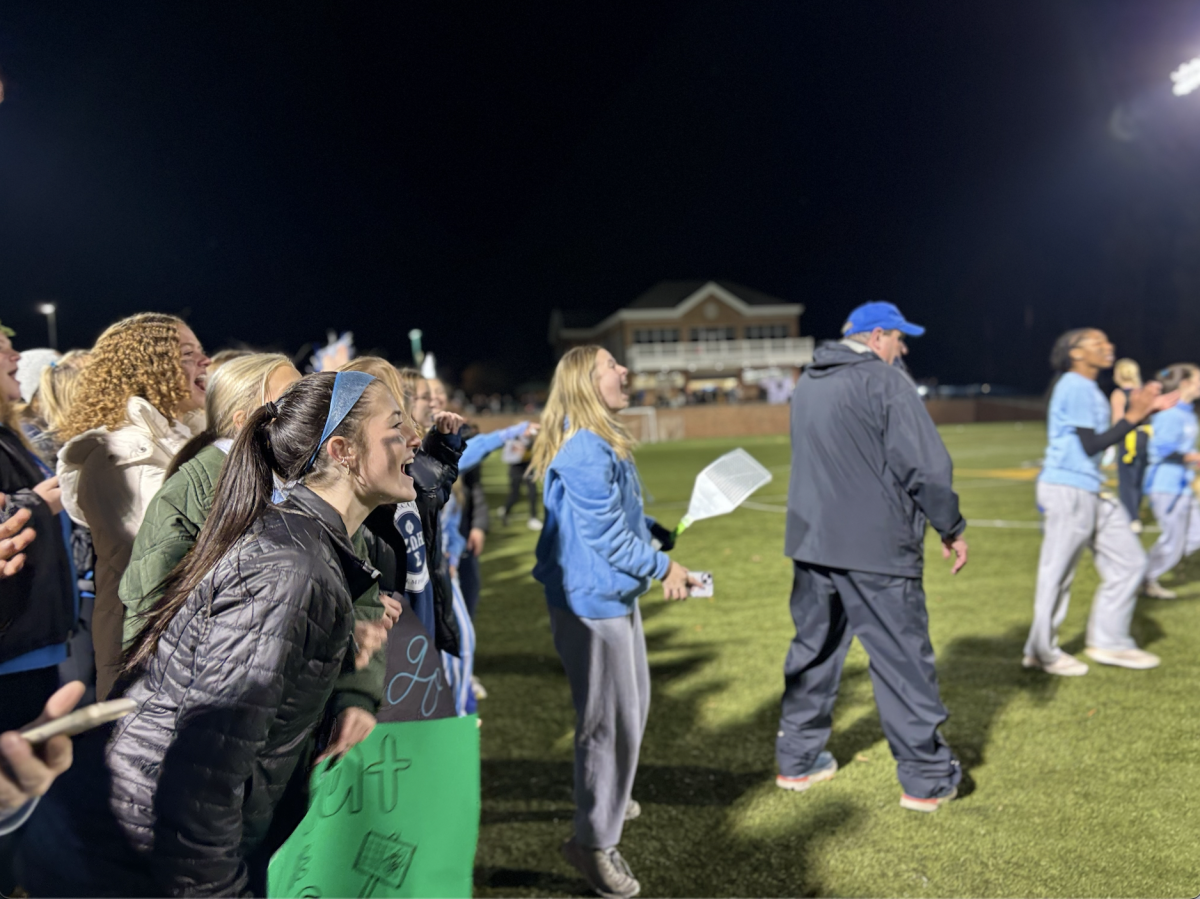 Excited SMS fans including Charlotte Stakem (11) and Pep Club President Shelby Williams (12) cheer on their fellow turkeys on the football field. 