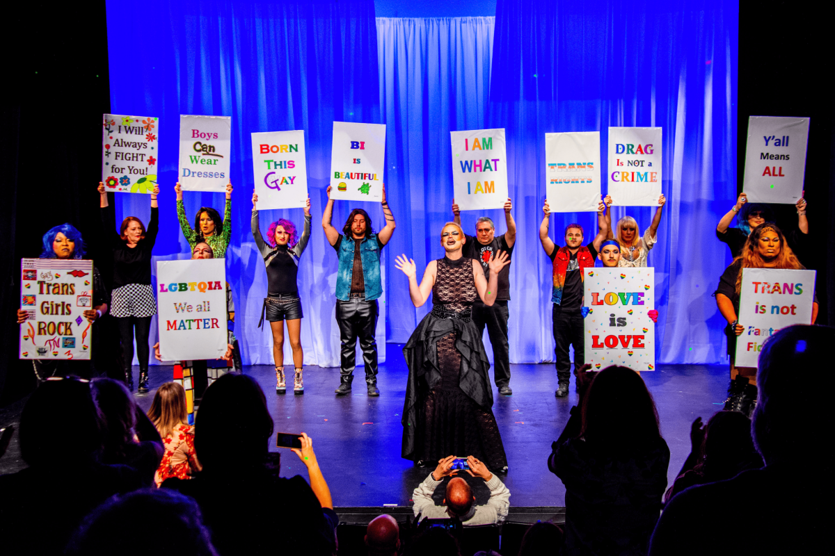 Friends of George take the stage with signs in support of drag and the LGBTQ community. 