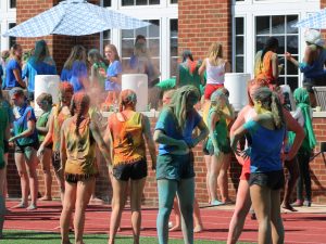 Upper Schoolers gather on the turf after the color war covered in powder. 