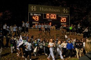 Students celebrate their win against Hutchison in the annual powderpuff game by crowding the score board. The Turkeys won by 23 points against the Bees. 