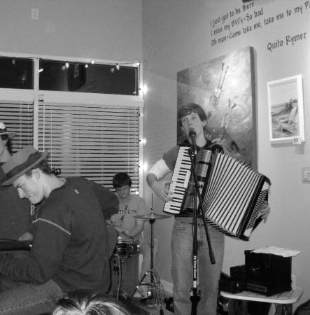 Nathan McHenry sings while playing the accordion during a concert for his high school band. 