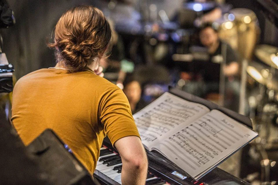 Music Teacher and Band Director Nathan McHenry plays keyboard in an Orchestra. 